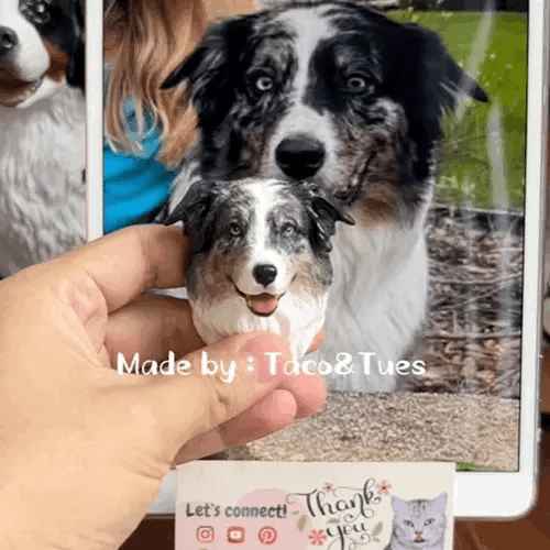 Hand holding a custom hand-painted Australian Shepherd dog figurine next to real dog photo on tablet, showing accurate likeness, made by Taco and Tues