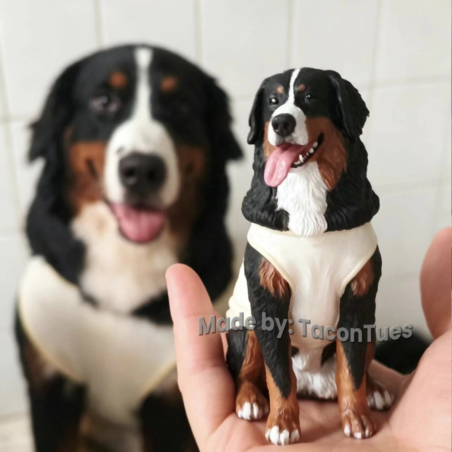 Hyper-realistic Bernese Mountain Dog sculpture by TaconTues, held in hand with real dog in background — custom pet memorial art for large breed lovers